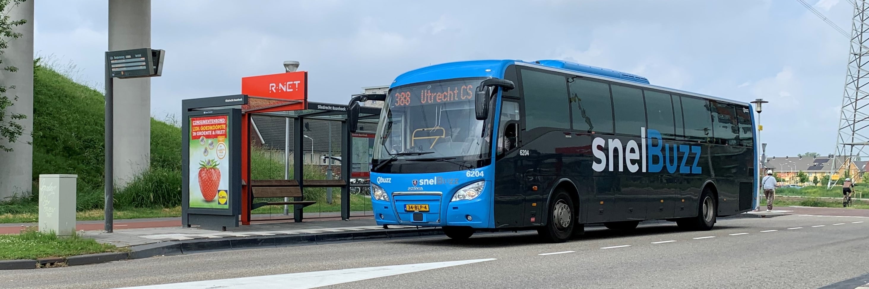 Een SnelBuzz staat bij een bushalte onder een viaduct