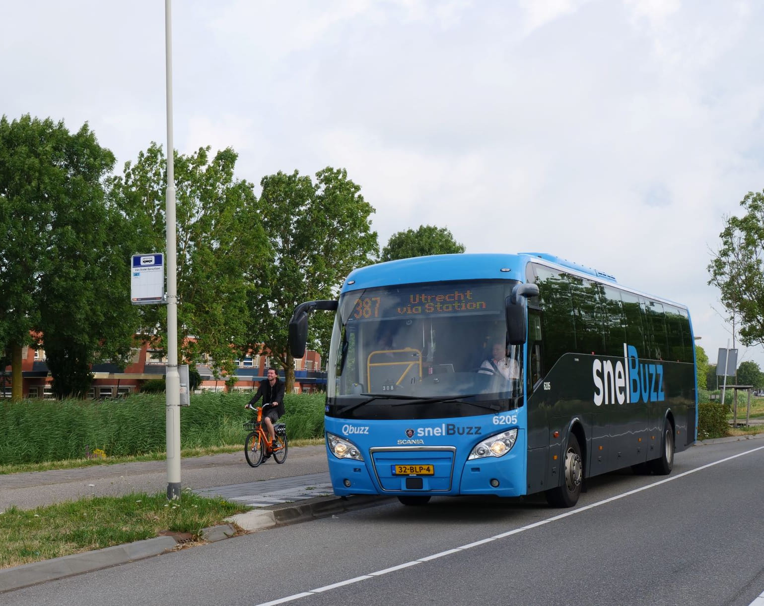 Een blauwe snelBuzz bij een halte.