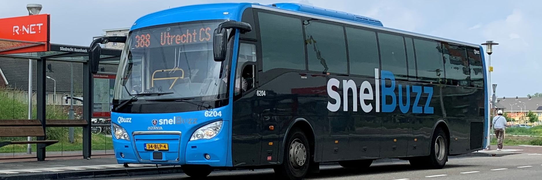 Een SnelBuzz staat bij een bushalte onder een viaduct